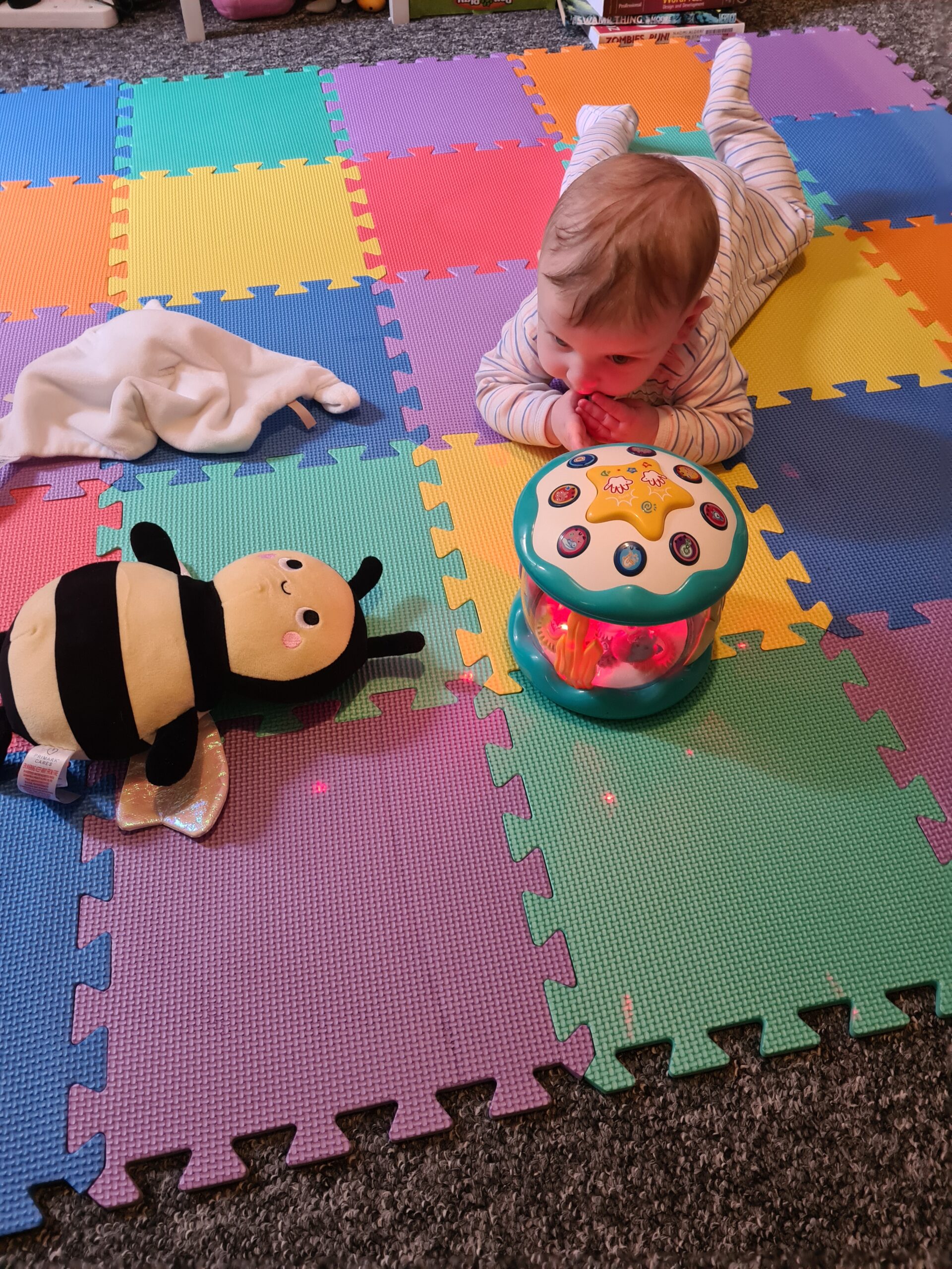 Tummy time with multi coloured tiles and bee toy