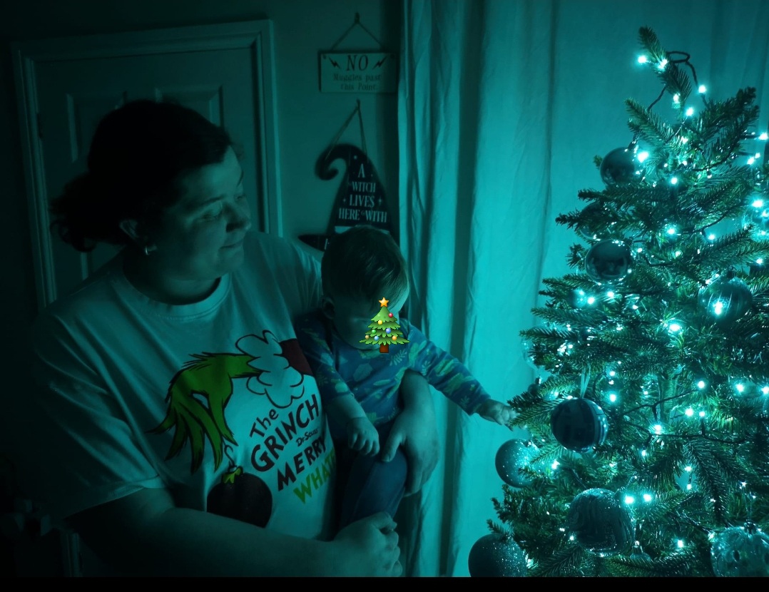 Baby and mum next to Christmas tree